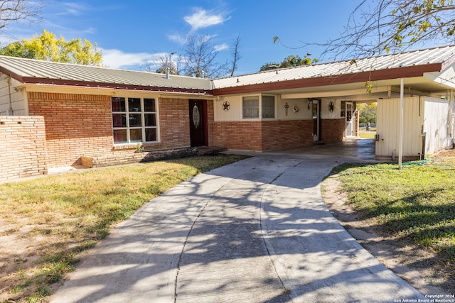 single story home featuring a front yard and a carport