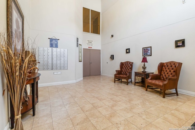 living area with a towering ceiling and mail boxes