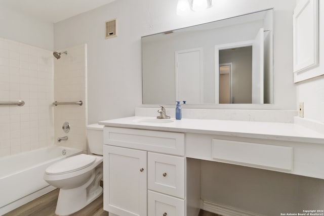 full bathroom with vanity, wood-type flooring, tiled shower / bath combo, and toilet