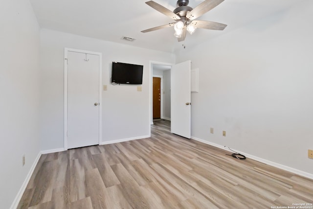 empty room with ceiling fan and light hardwood / wood-style flooring