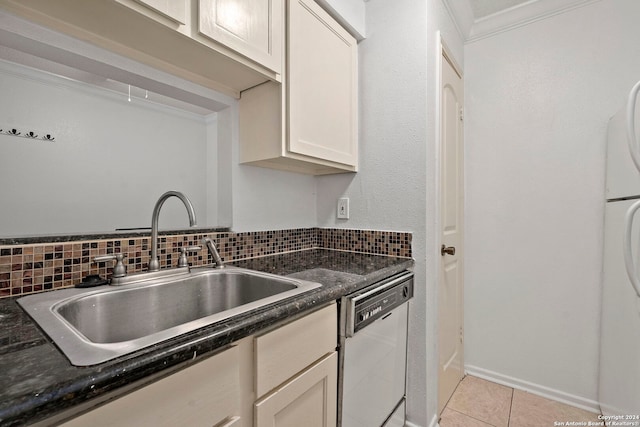 kitchen with backsplash, dark stone counters, dishwashing machine, sink, and light tile patterned flooring