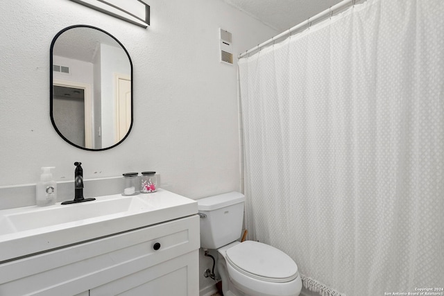 bathroom featuring a textured ceiling, toilet, and sink