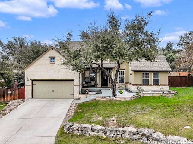 view of front of property featuring covered porch, a garage, and a front yard