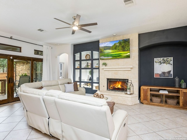 living room featuring ceiling fan, light tile patterned floors, and a fireplace