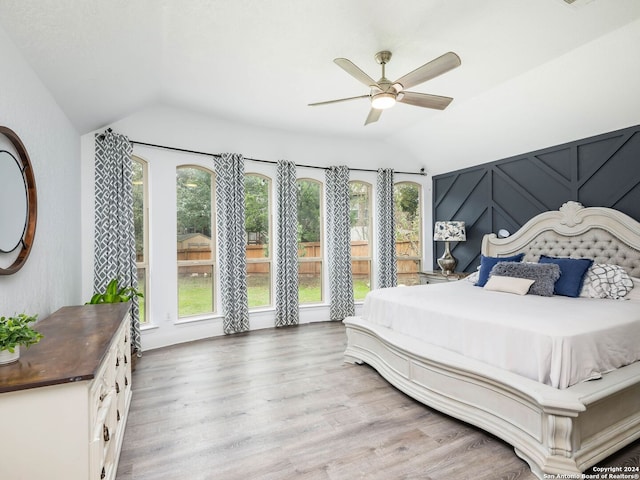 bedroom featuring light hardwood / wood-style floors, ceiling fan, and lofted ceiling