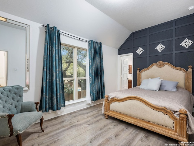 bedroom with hardwood / wood-style floors and vaulted ceiling