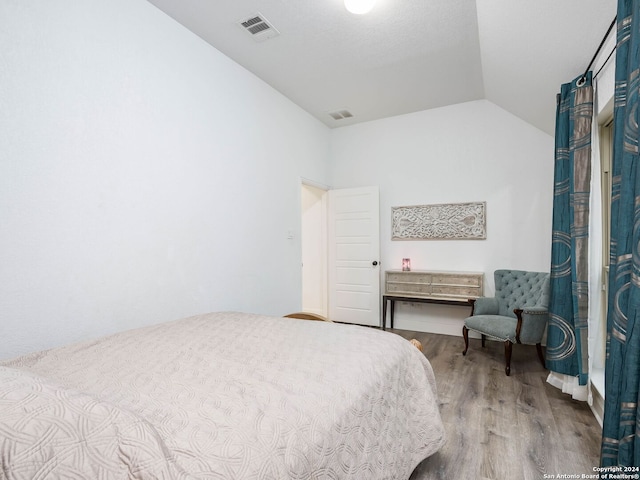 bedroom featuring hardwood / wood-style flooring and lofted ceiling