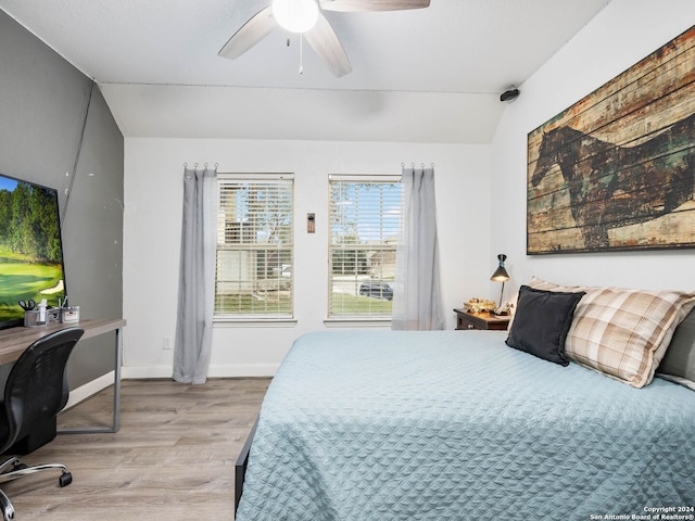 bedroom with ceiling fan, light hardwood / wood-style flooring, and lofted ceiling