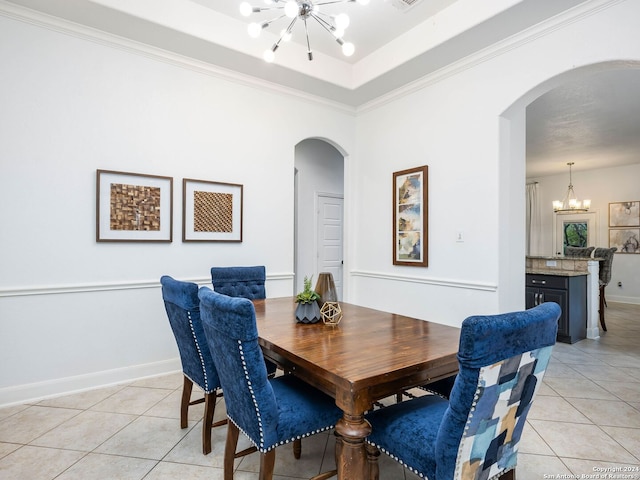 tiled dining room with a notable chandelier and ornamental molding