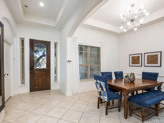 tiled dining space featuring a chandelier and a tray ceiling