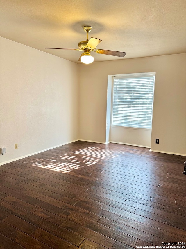 spare room featuring dark hardwood / wood-style floors and ceiling fan