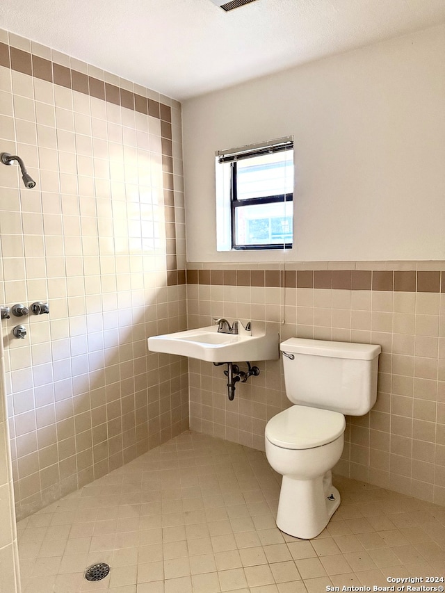 bathroom featuring tile walls and toilet