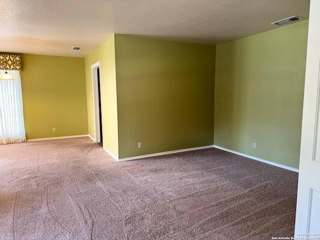 carpeted empty room with a textured ceiling