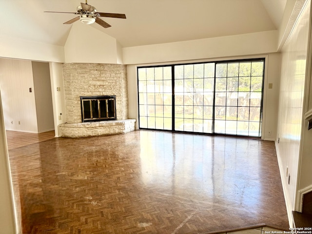 unfurnished living room featuring ceiling fan, a stone fireplace, and high vaulted ceiling