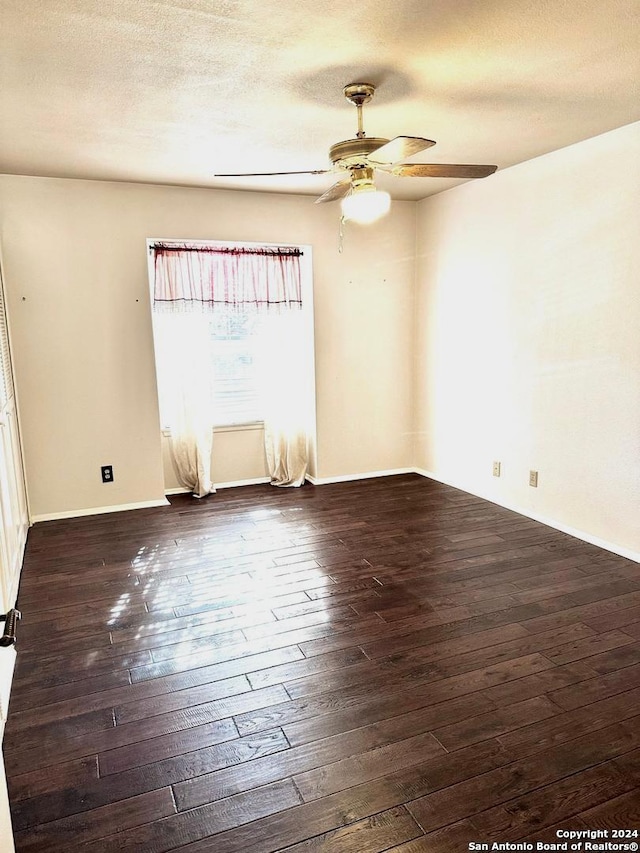 spare room with ceiling fan, dark wood-type flooring, and a textured ceiling