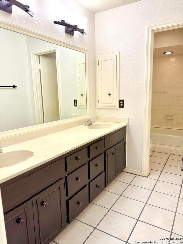 full bathroom featuring tile patterned flooring, vanity, toilet, and tiled shower / bath