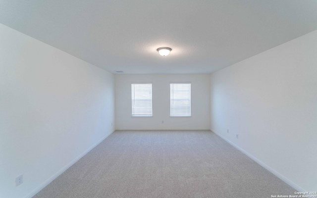 carpeted spare room featuring a textured ceiling