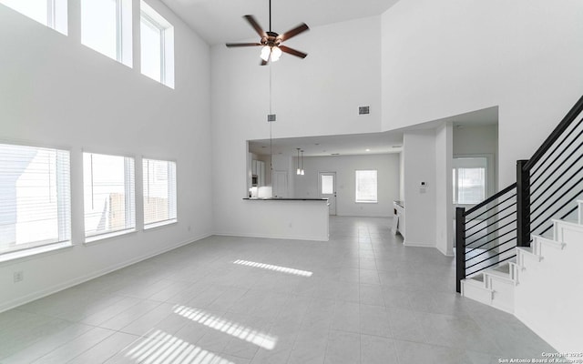127 Gathering Dr, San Antonio, TX 78253 - unfurnished living room with a ceiling fan, stairway, a high ceiling, and light tile patterned floors