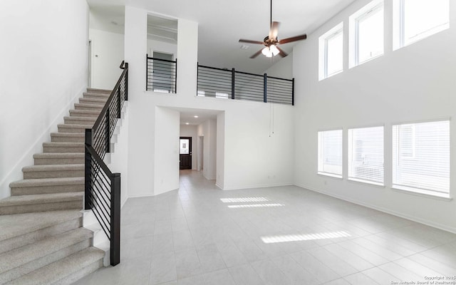 127 Gathering Dr, San Antonio, TX 78253 - unfurnished living room with ceiling fan, stairway, a towering ceiling, and tile patterned floors