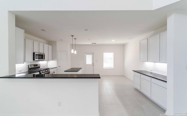 127 Gathering Dr, San Antonio, TX 78253 - kitchen with stainless steel appliances, decorative backsplash, dark countertops, light tile patterned flooring, and a peninsula