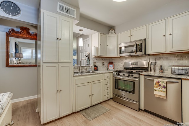 8058 Broadway Unit 147U, San Antonio, TX 78209 - kitchen with stainless steel appliances, a sink, backsplash, and light wood finished floors