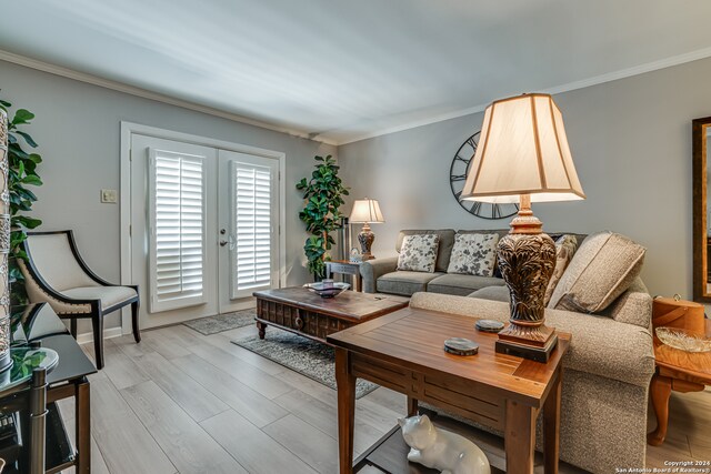 living room featuring french doors, light wood-type flooring, and crown molding