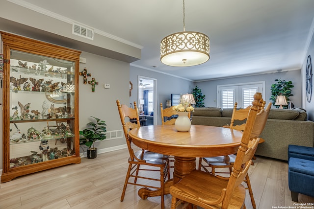 dining space featuring french doors, light hardwood / wood-style flooring, and ornamental molding