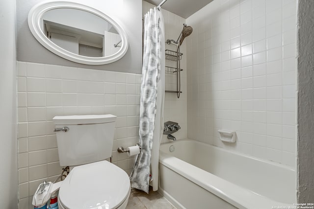 bathroom with toilet, shower / bathtub combination with curtain, and tile walls