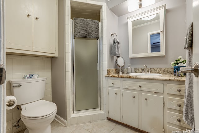 bathroom featuring tile patterned flooring, vanity, toilet, and a shower with door