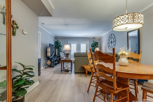 dining space with crown molding and light wood-type flooring