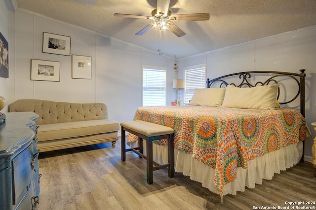 bedroom featuring crown molding, vaulted ceiling, hardwood / wood-style flooring, ceiling fan, and a textured ceiling