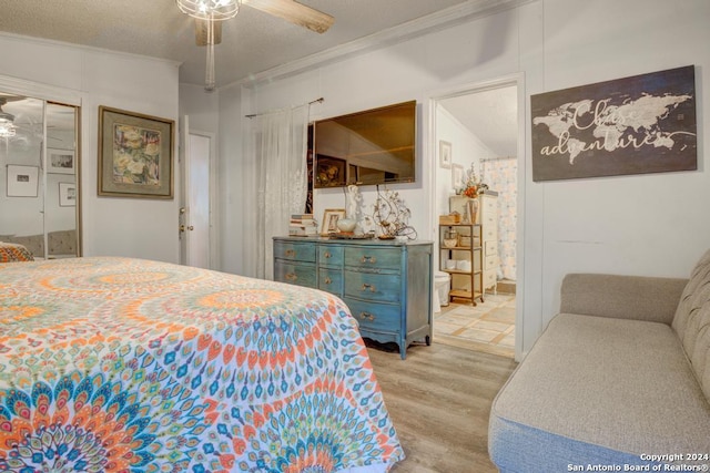 bedroom featuring a textured ceiling, ceiling fan, light hardwood / wood-style floors, and crown molding