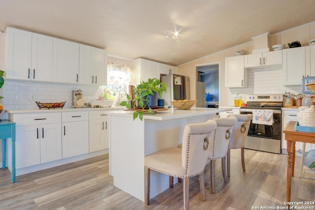 kitchen featuring white cabinetry, a center island, light hardwood / wood-style flooring, a breakfast bar area, and appliances with stainless steel finishes