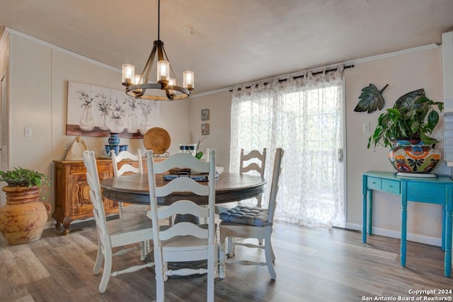 dining space with light wood-type flooring, crown molding, and an inviting chandelier