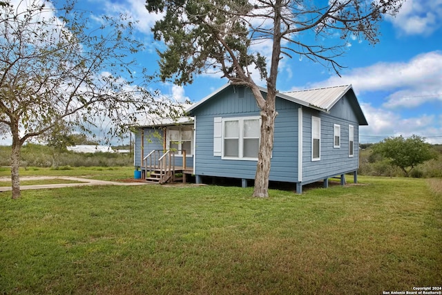 rear view of house featuring a yard