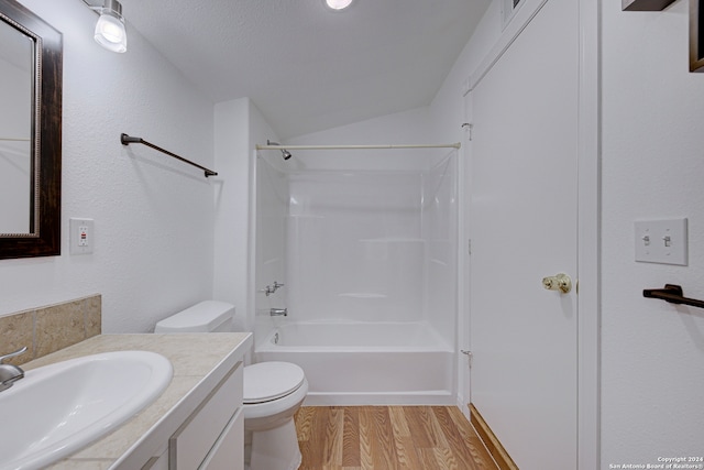 full bathroom featuring hardwood / wood-style floors, vanity, vaulted ceiling, toilet, and a textured ceiling