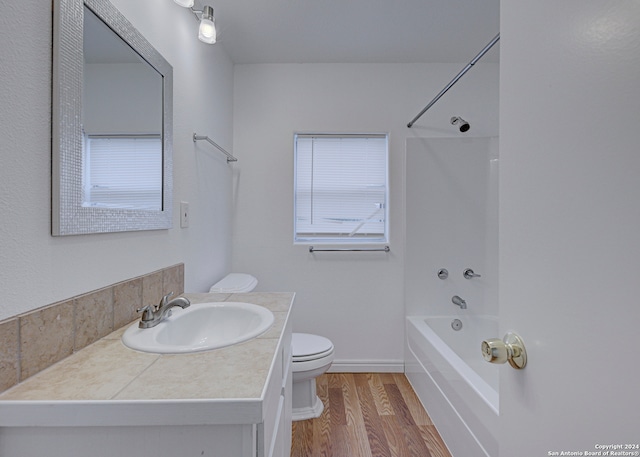 full bathroom featuring hardwood / wood-style floors, vanity, tub / shower combination, and toilet