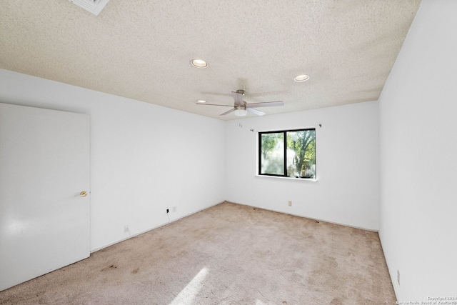 carpeted empty room with ceiling fan and a textured ceiling