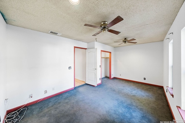 interior space with ceiling fan, dark carpet, and a textured ceiling