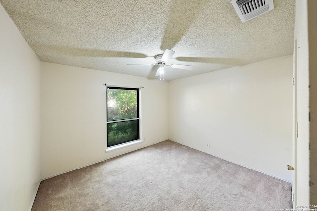 empty room featuring carpet flooring, ceiling fan, and a textured ceiling