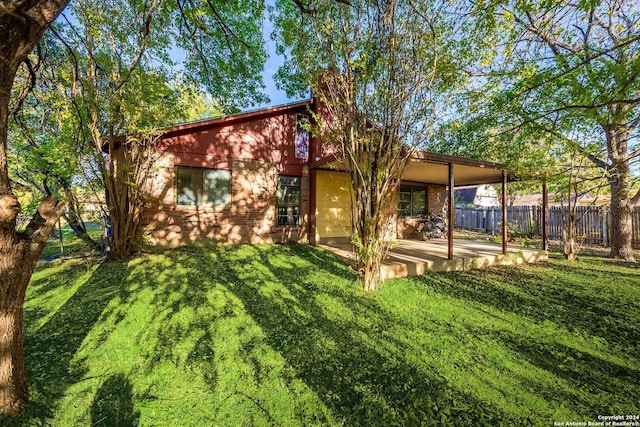 rear view of house with a lawn and a patio area