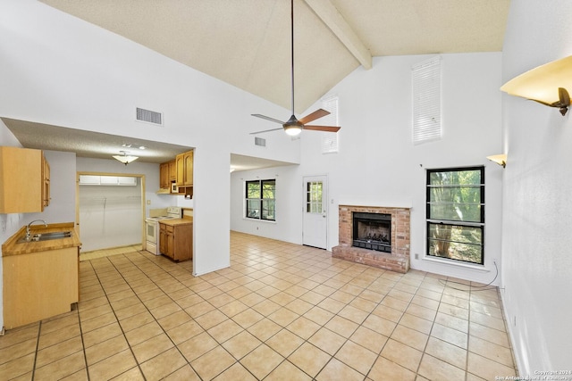 unfurnished living room featuring beamed ceiling, light tile patterned floors, and high vaulted ceiling