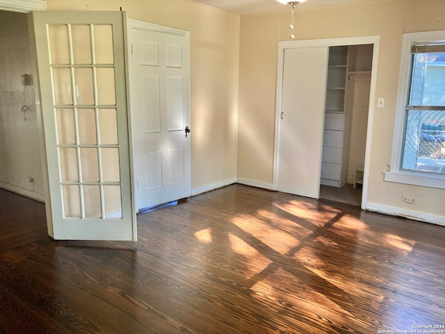 unfurnished bedroom with dark hardwood / wood-style floors and a textured ceiling