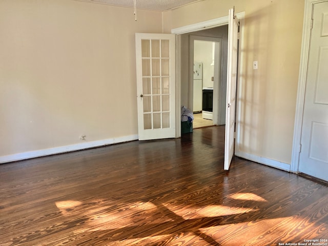 unfurnished room featuring dark hardwood / wood-style flooring, a textured ceiling, and french doors