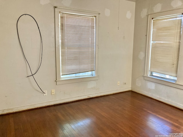 unfurnished room with a wealth of natural light and dark wood-type flooring