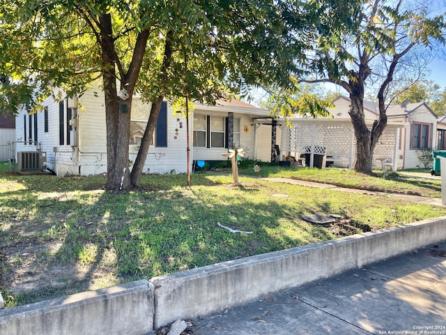 view of front of property featuring central AC unit and a front lawn