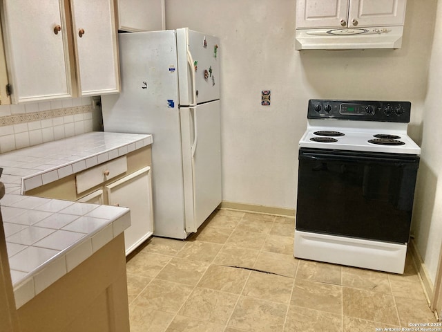 kitchen featuring white cabinetry, tile counters, and white appliances