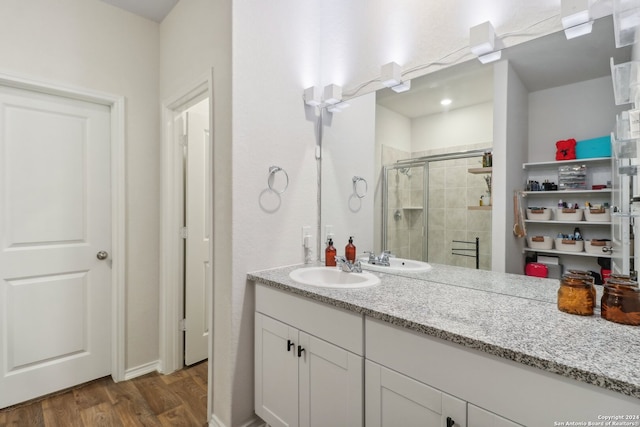 bathroom featuring vanity, hardwood / wood-style flooring, and a shower with door