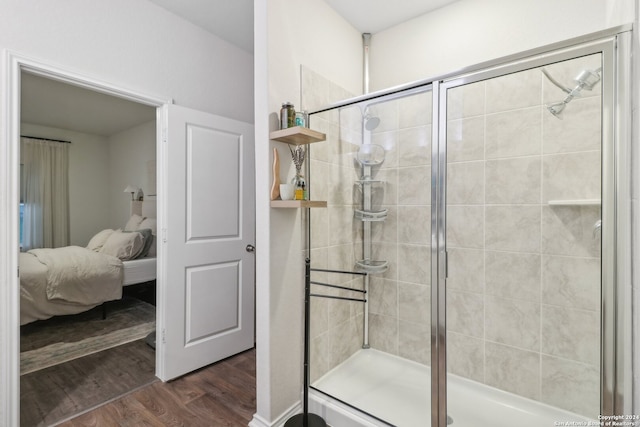 bathroom with hardwood / wood-style floors and a shower with shower door