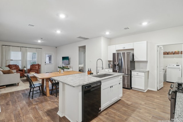 kitchen with white cabinetry, sink, stainless steel appliances, light hardwood / wood-style flooring, and washer / clothes dryer